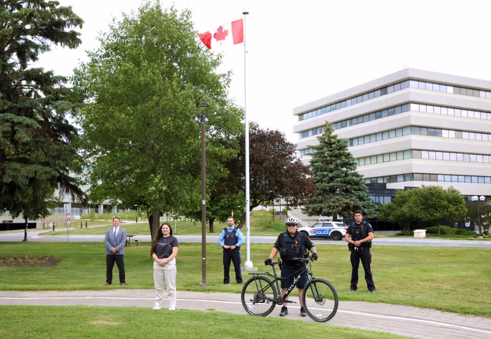 GSPS wearing orange ribbons on Canada Day people wearing orange ribbons standing in front of Canadian flag