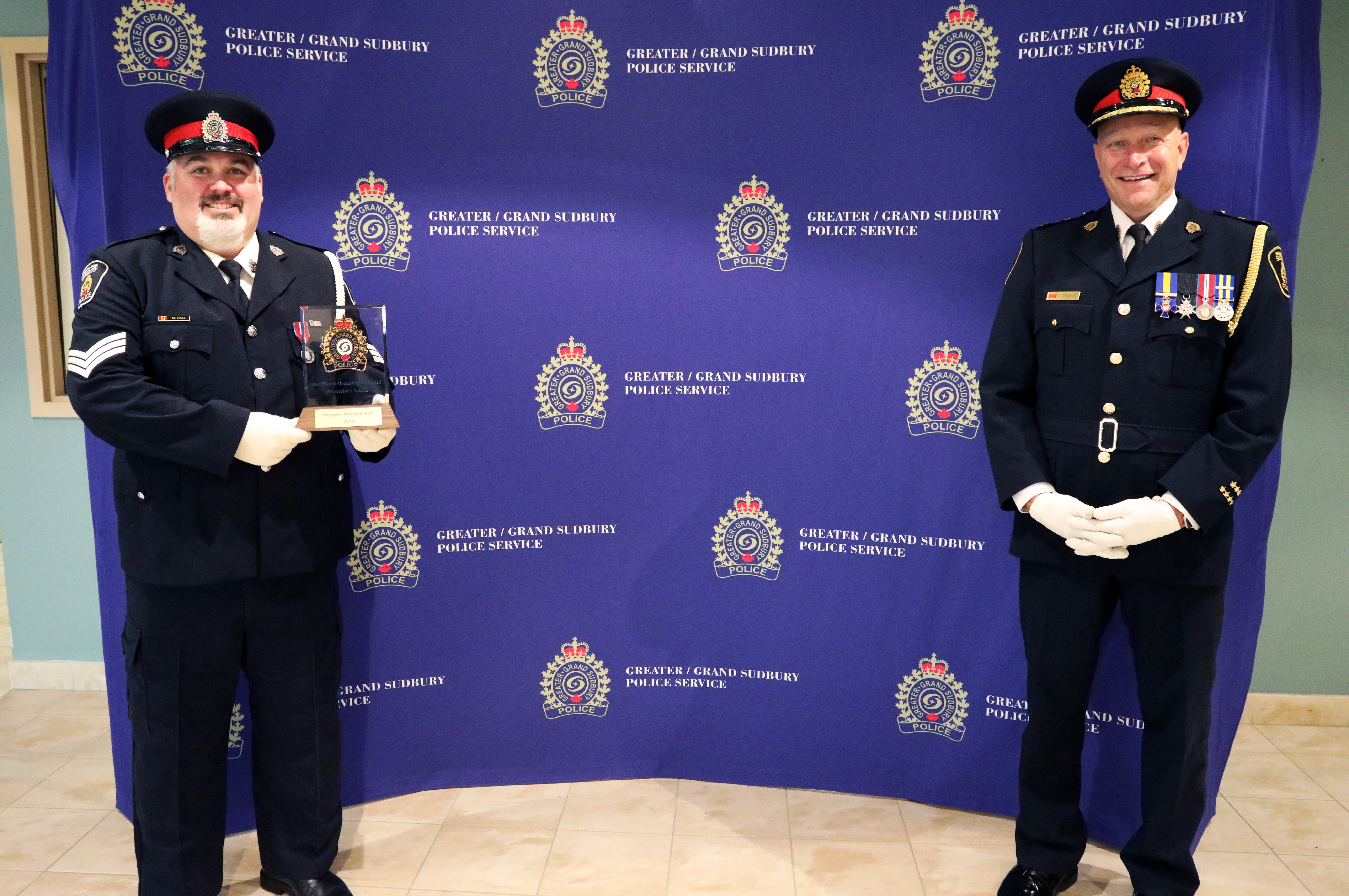 Sgt Matt Hall and Chief Pedersen two men in uniform holding award