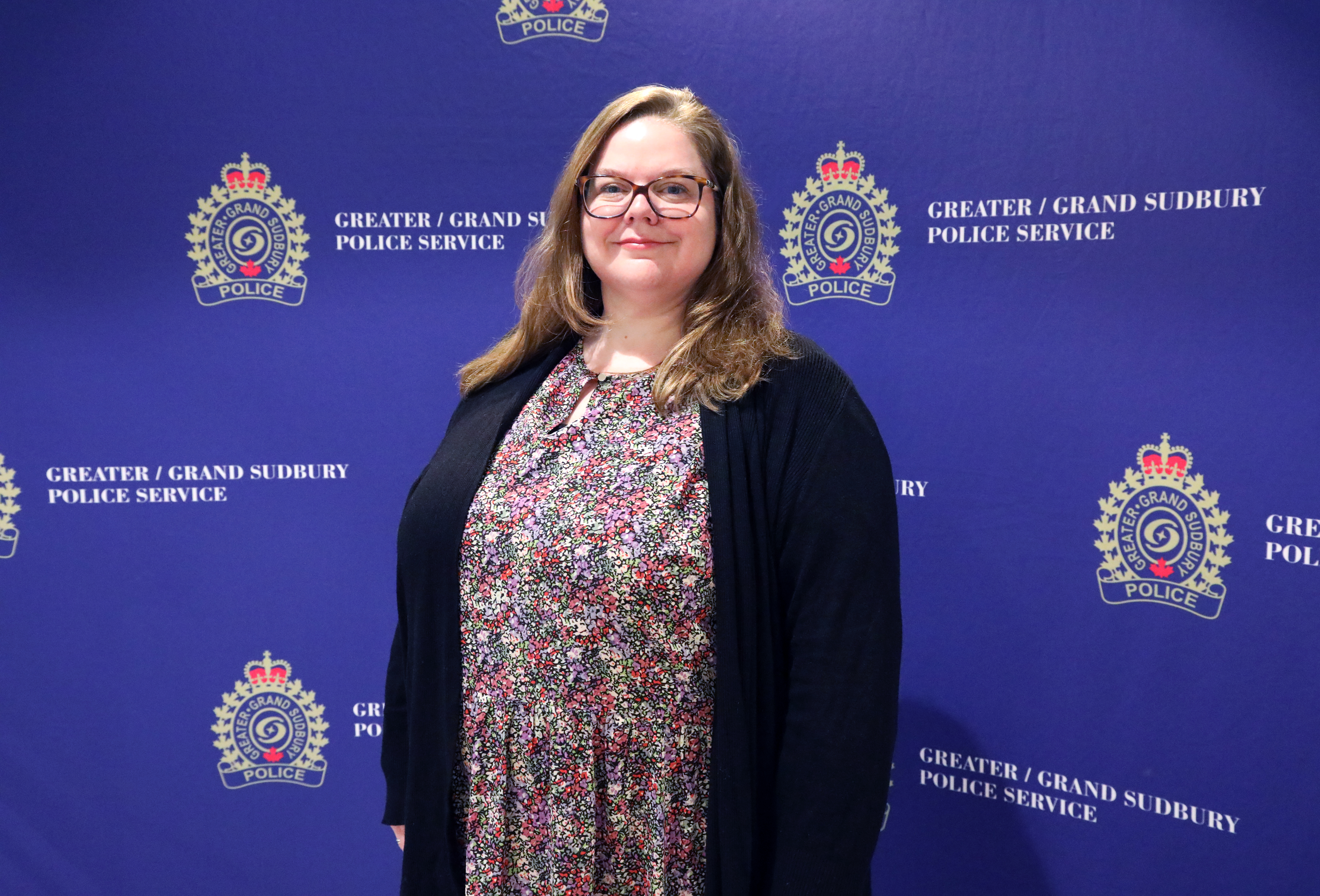 Heather Lewis woman standing in front of media wall