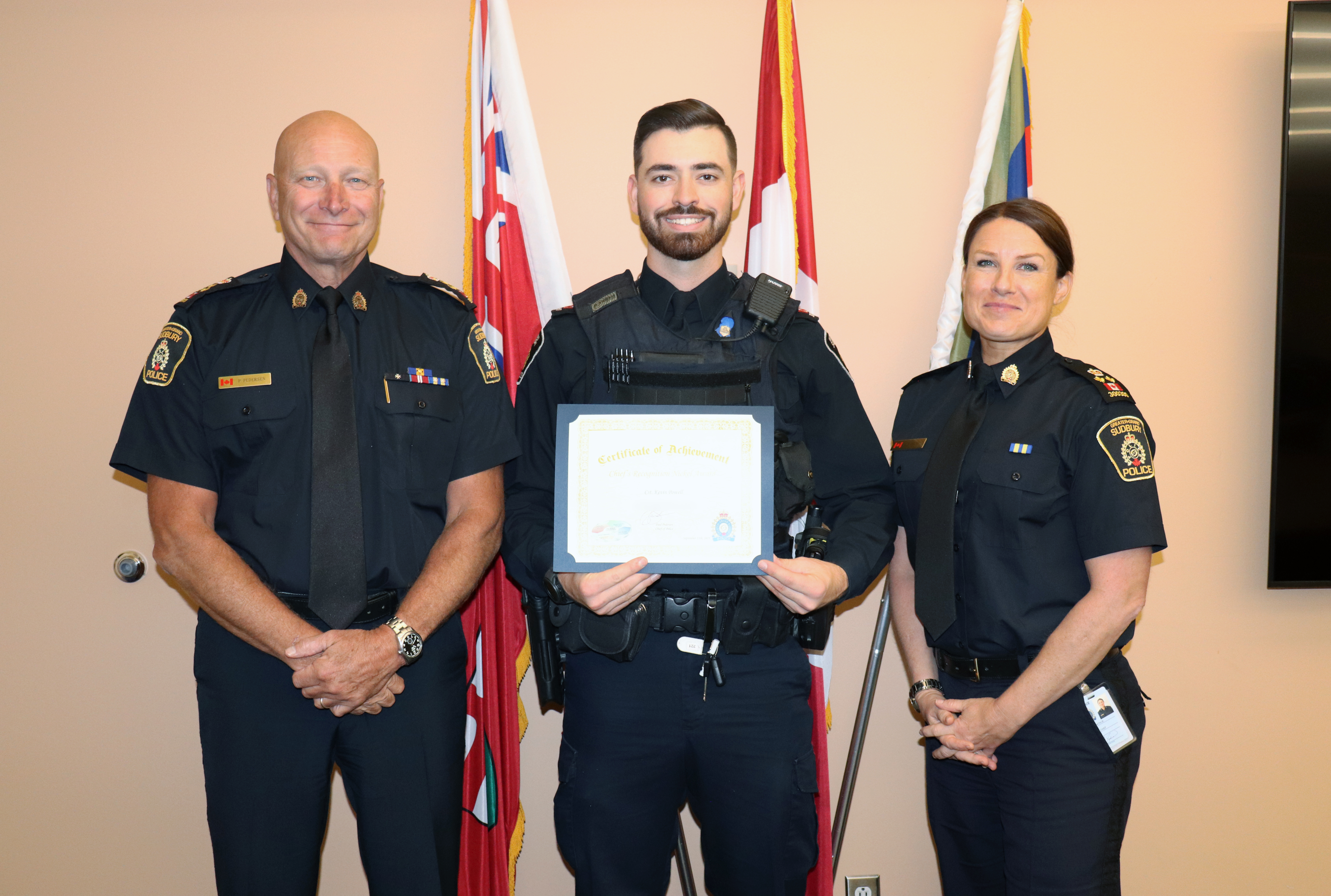 Chief Pedersen, Cst. Kevin Powell and Deputy Chief Natalie Hiltz Three uniformed individuals smiling and holding certificate