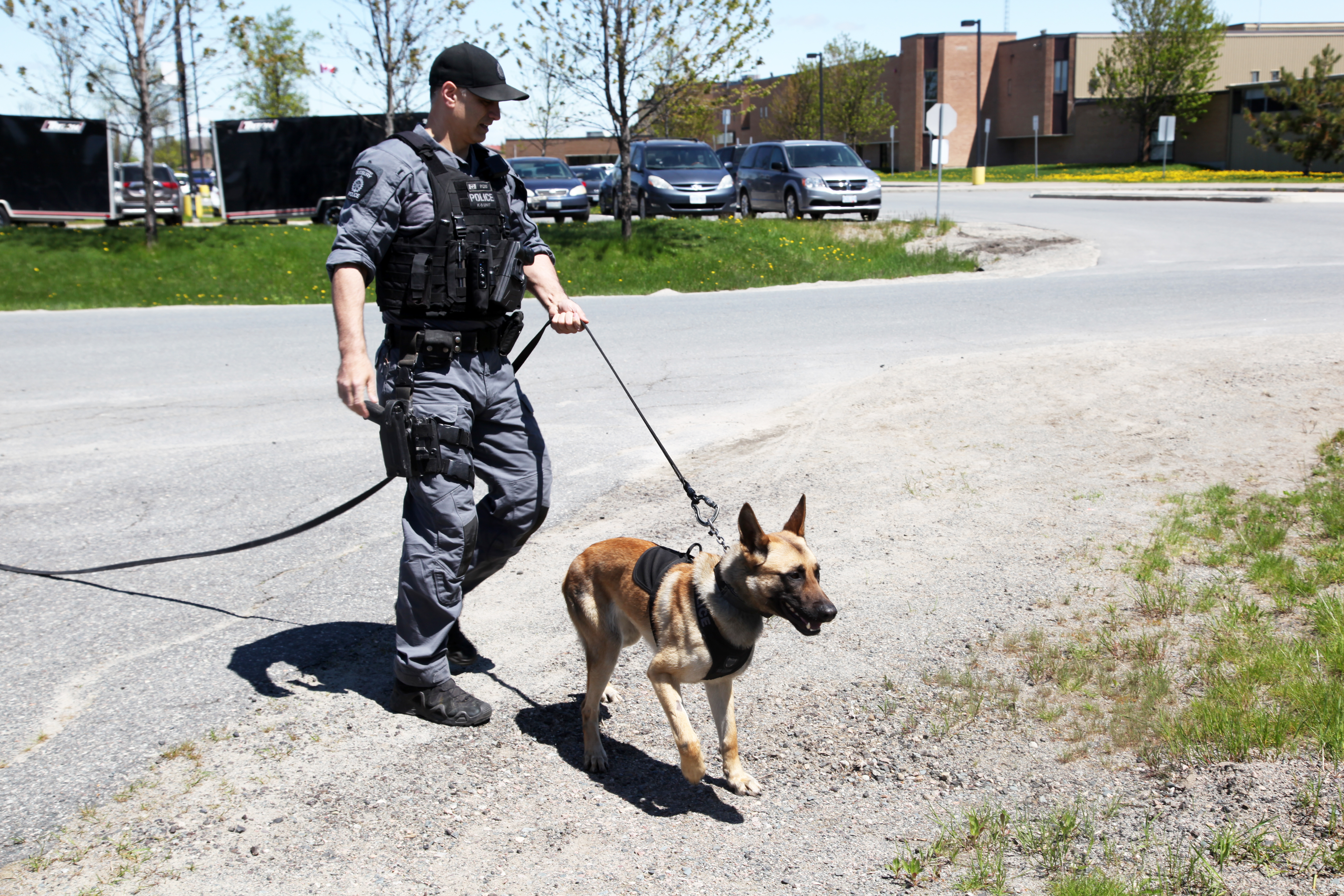 Cst. Robinson and PSD Leo Officer walking police dog outdoors on leash