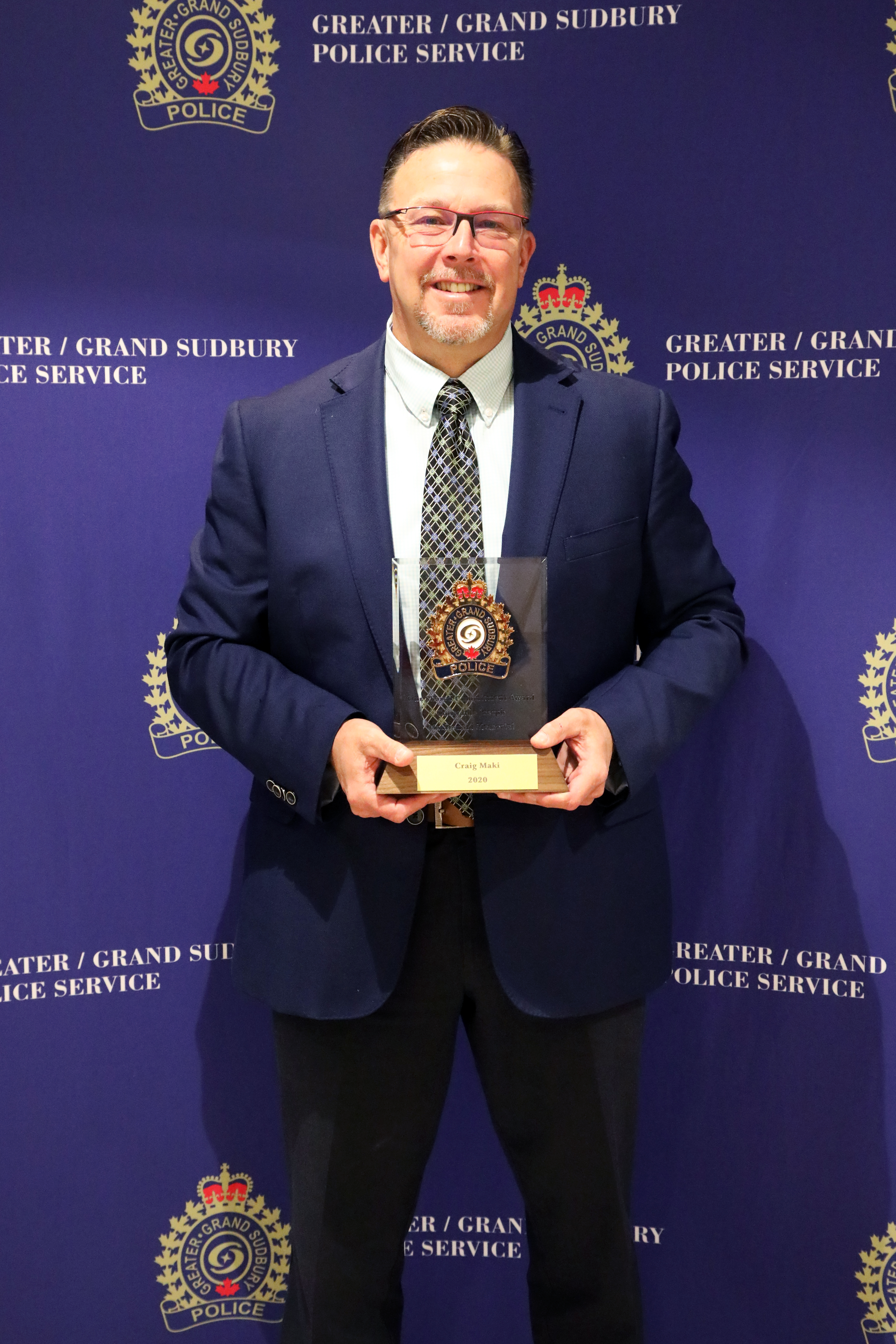 Craig Maki man smiling and holding award