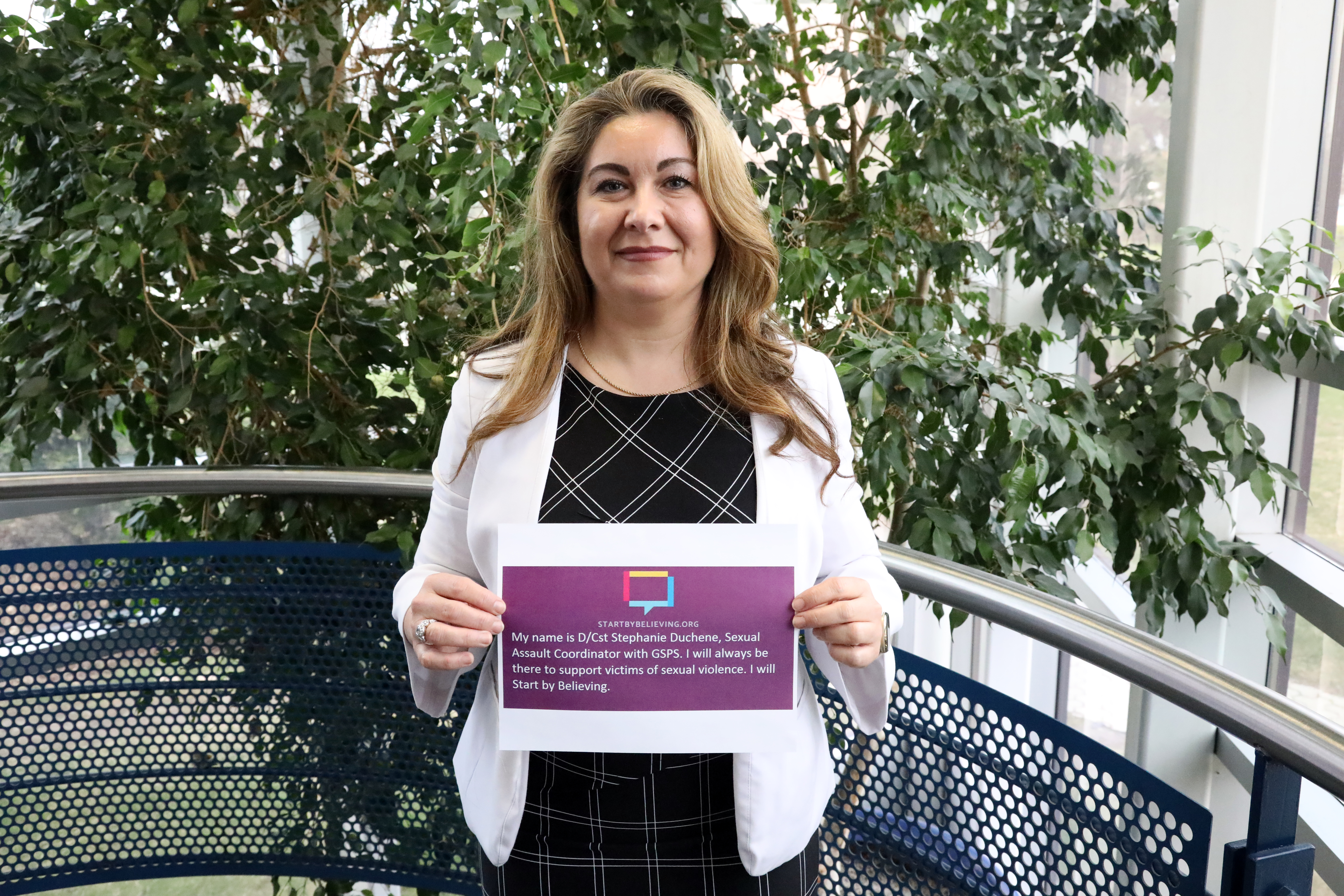 Detective Constable Stephanie Duchene officer standing holding a sign