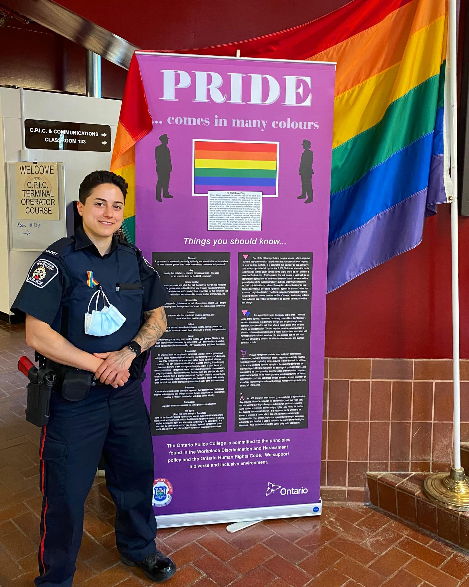 Sabrina Stalteri person standing in front of pride flag and banner