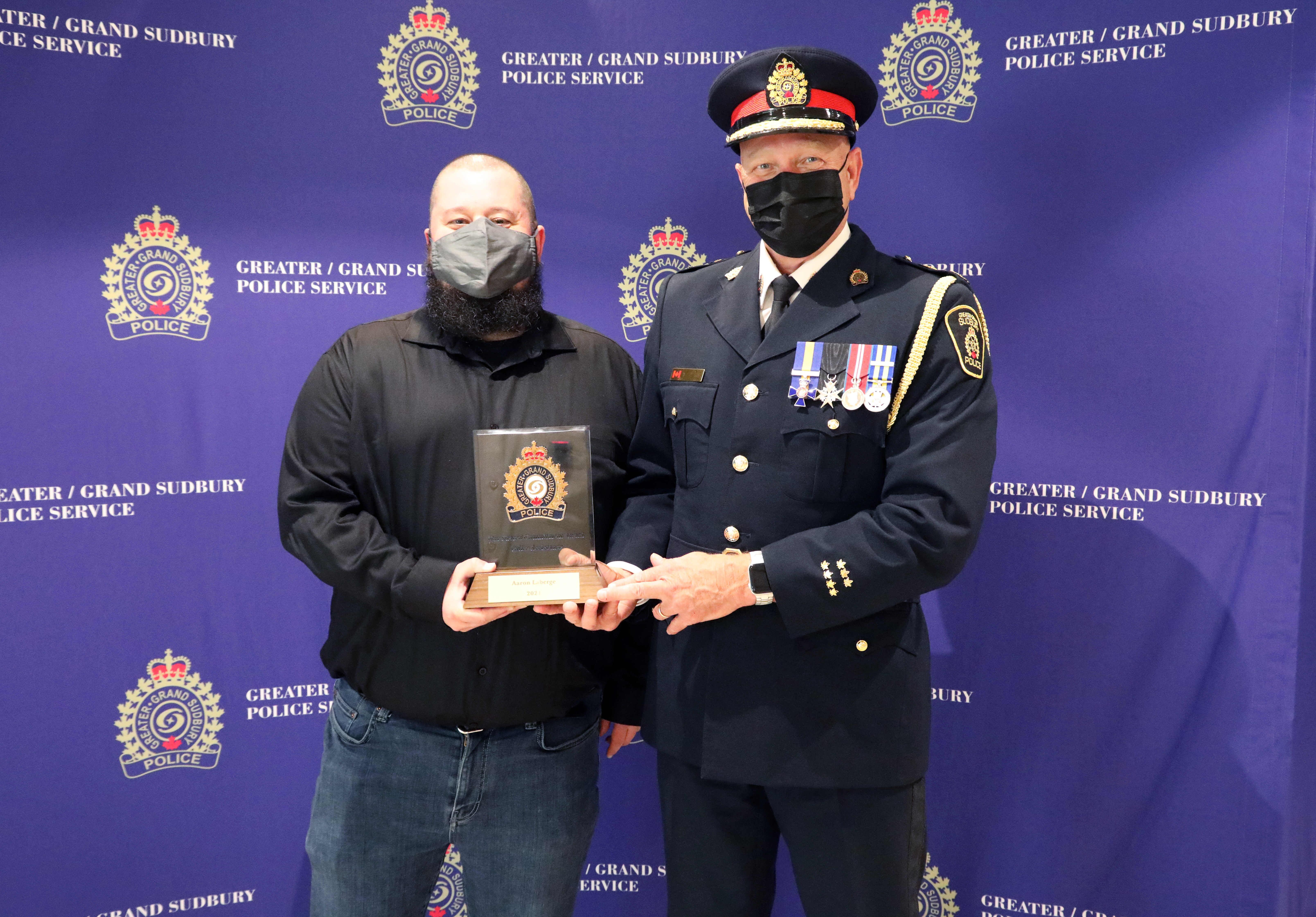 Aaron Laberge and Chief Pedersen man standing with Chief of Police holding award