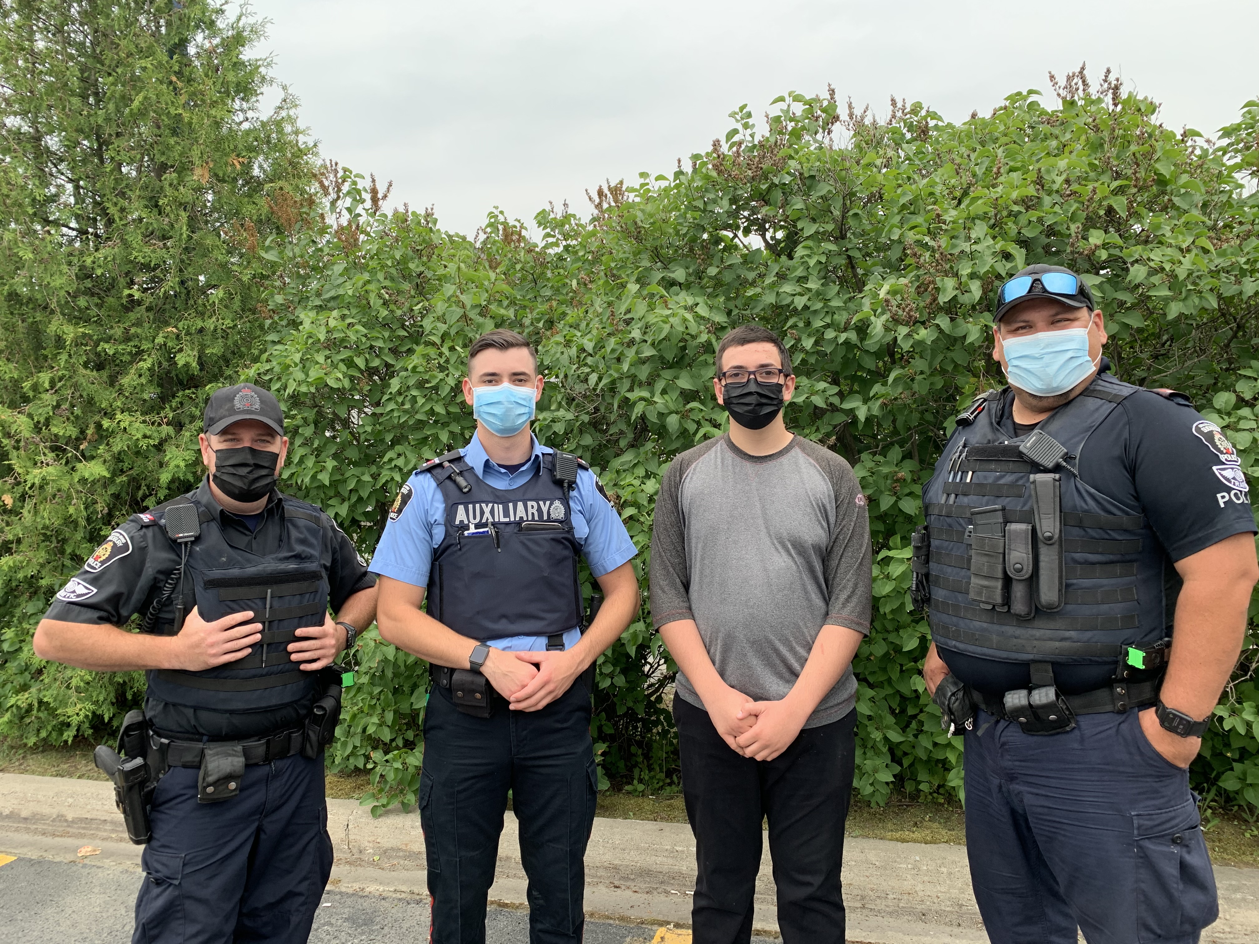 Officers and community member Four men standing wearing masks