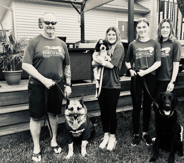 K9 Leo and his family people standing smiling with dog
