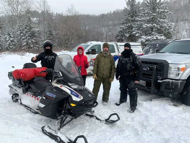 GSPS Rural officers rescue two individuals four people standing outside in the snow in the bush