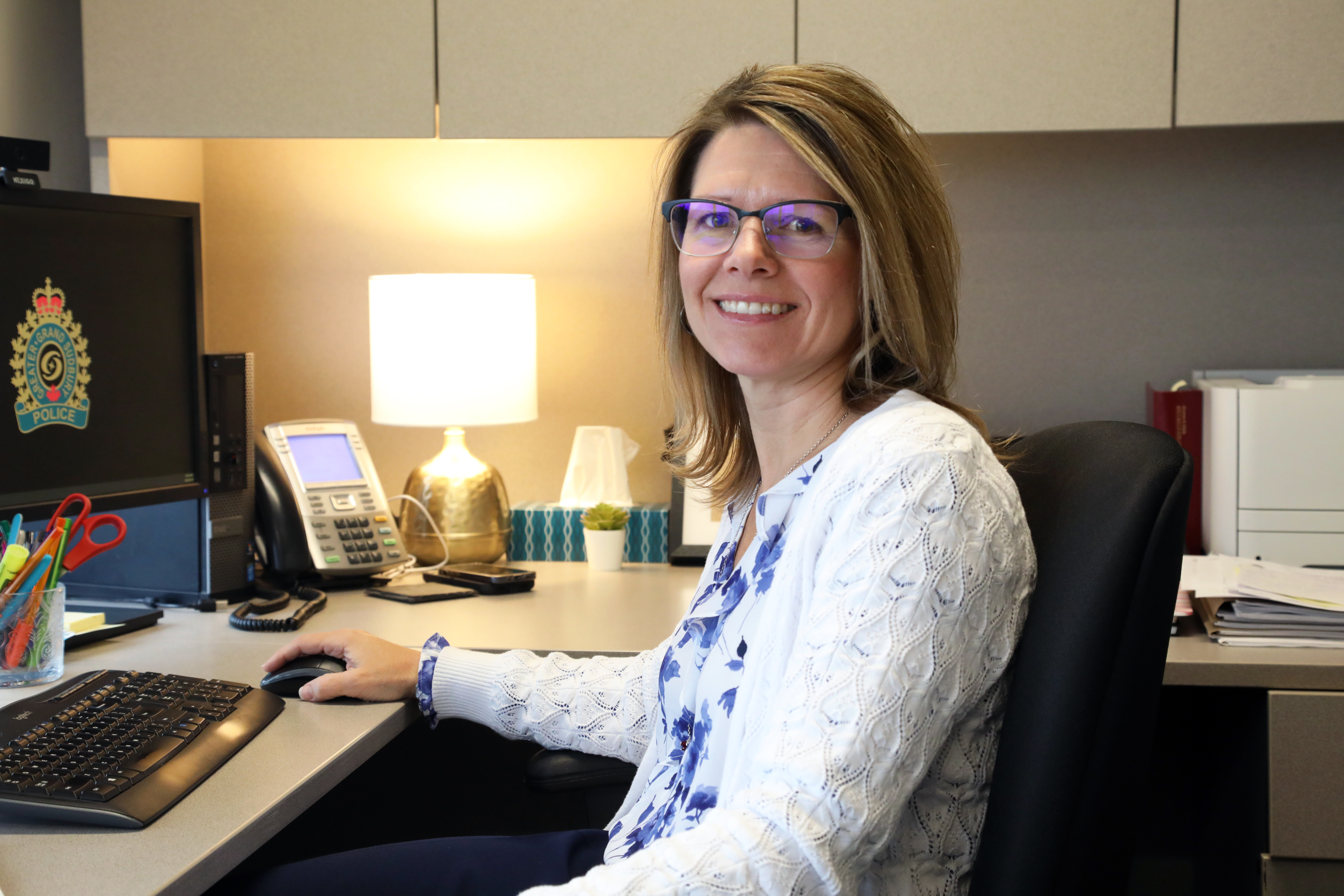 Andrea Savage woman smiling sitting at desk