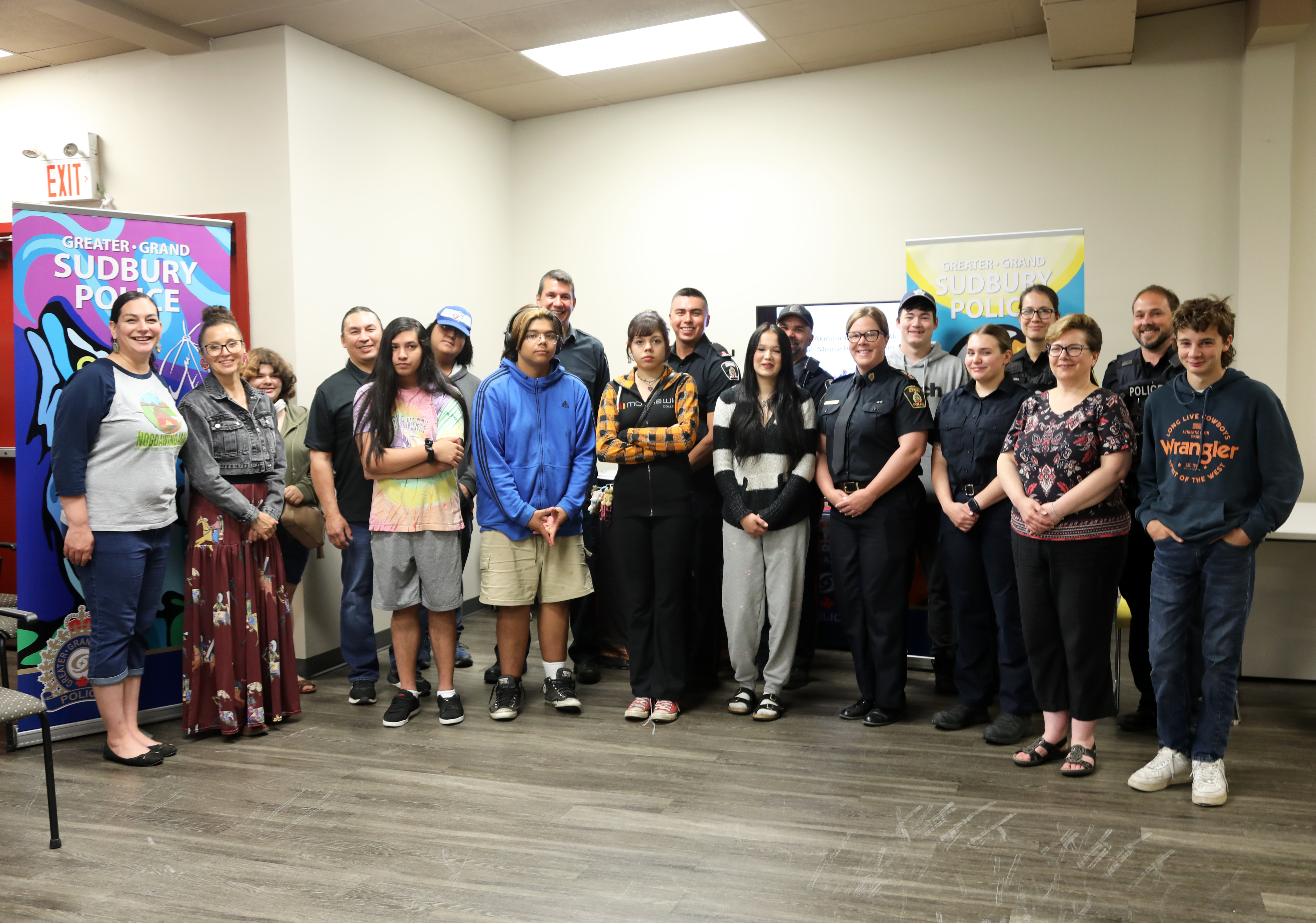 Officers and youth group of police officers and youth standing and smiling