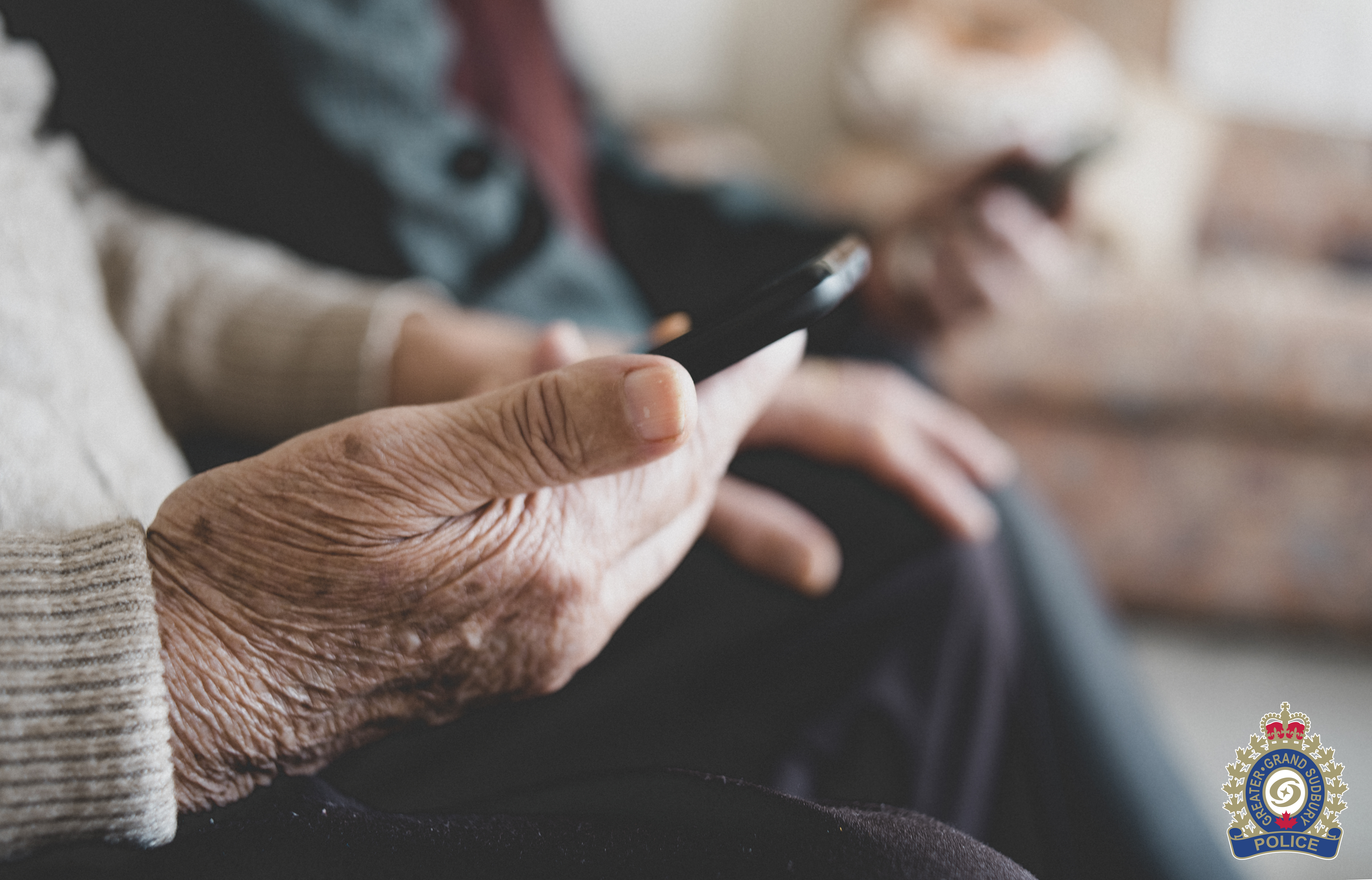 grandparent scam close up of man's hand holding cell phone