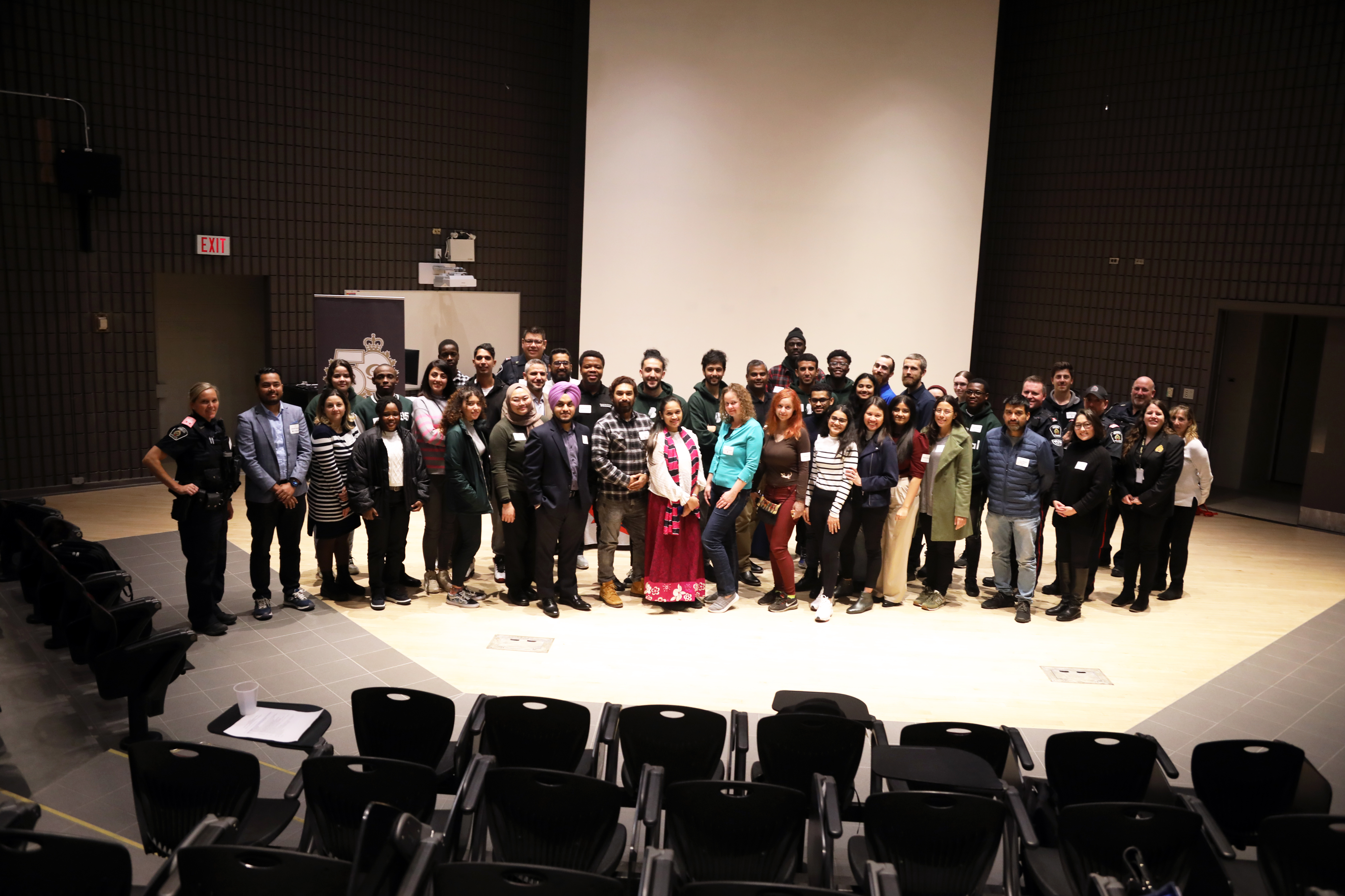 Intercultural Ride Along participants group of people standing in auditorium