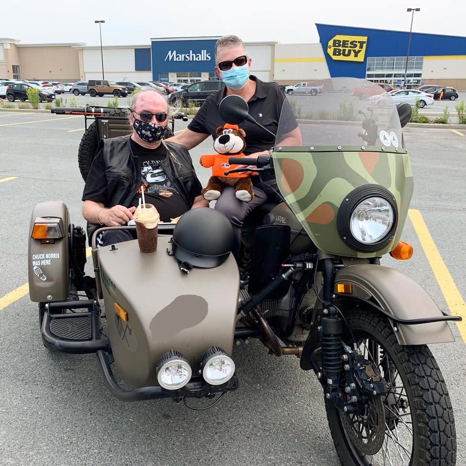 Jim Oman and A&W owner two people sitting in motorcycle with teddy bear