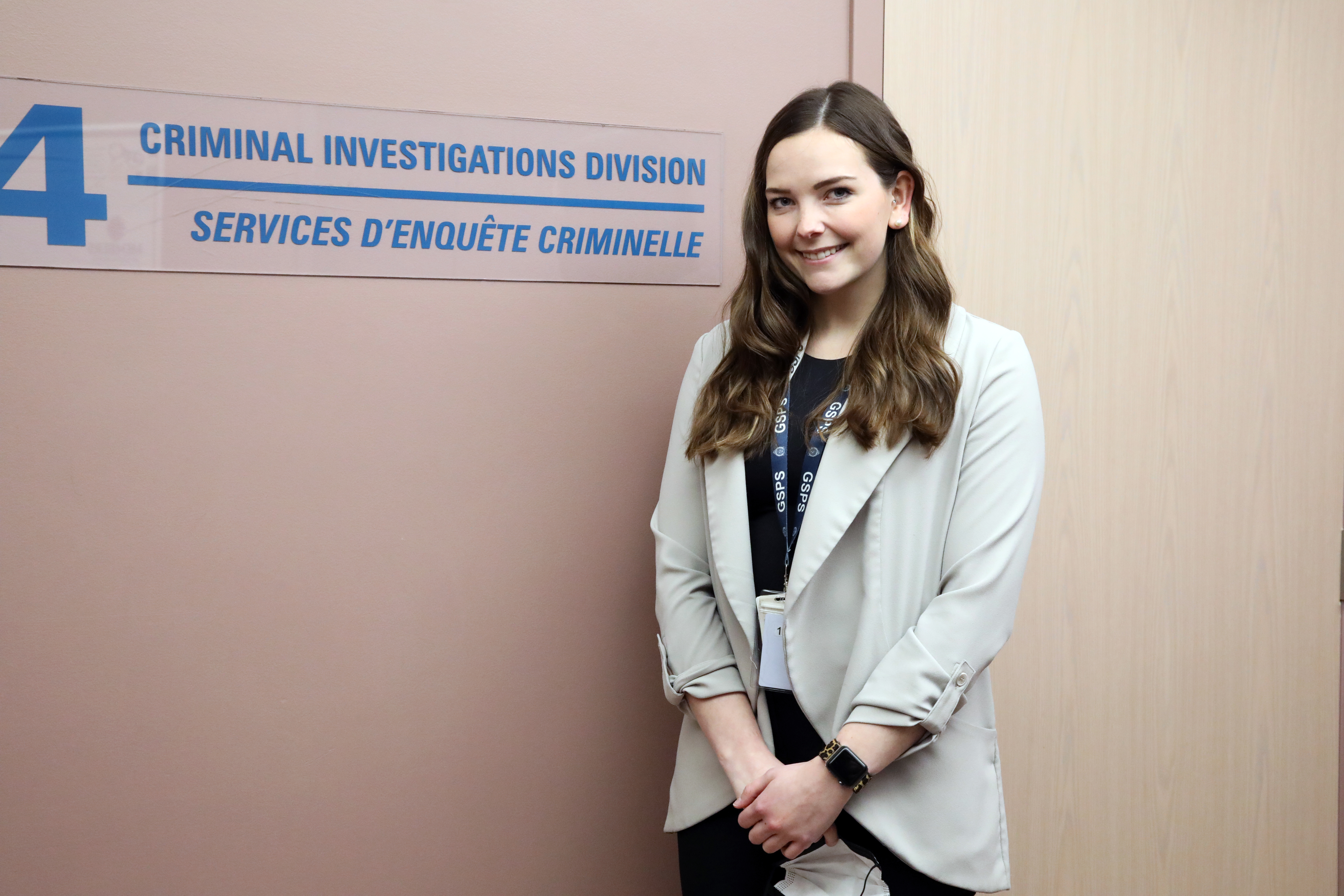 Julia Kinna woman standing and smiling in police building