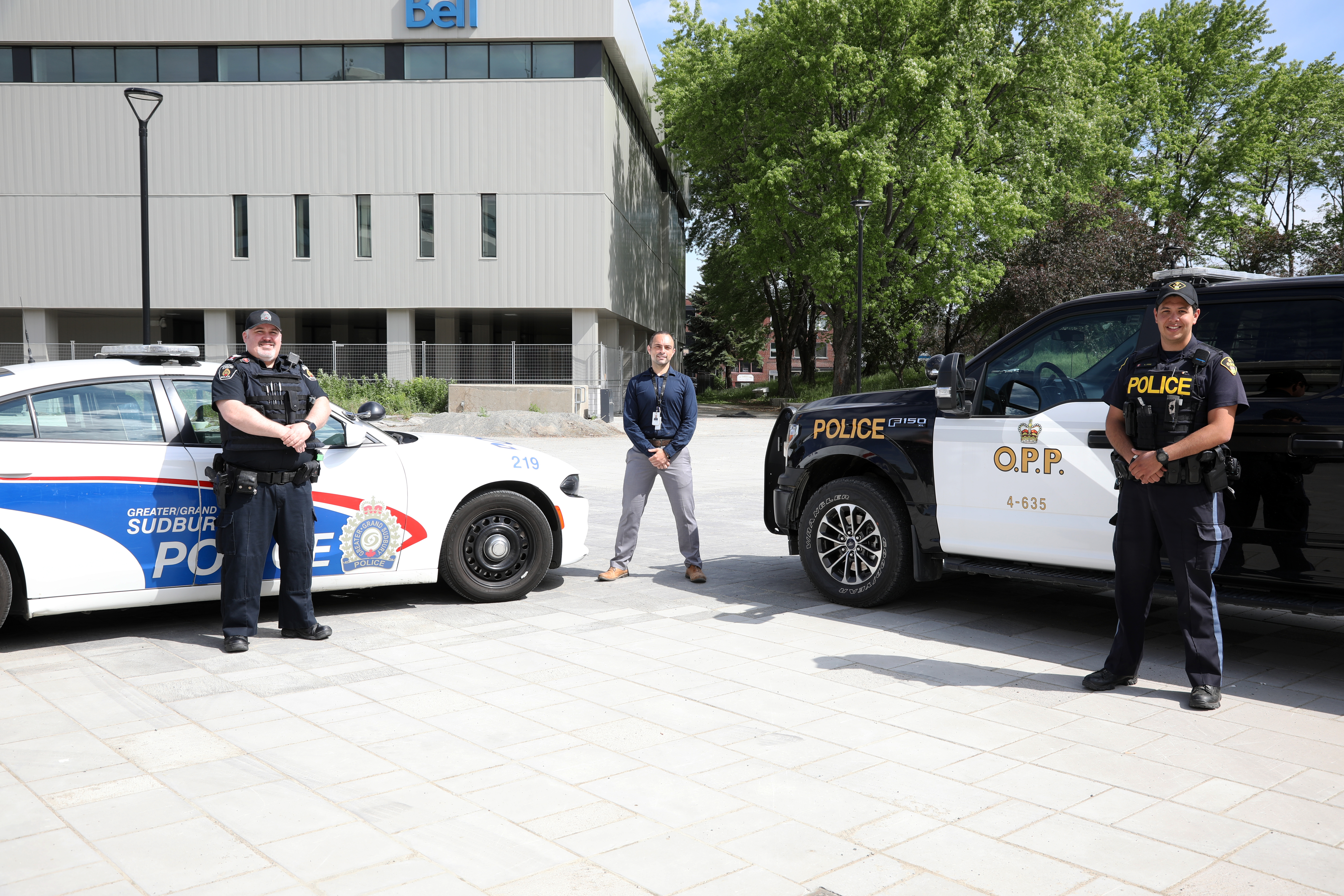 MCRRT Two police officers and health representative standing between police cruisers